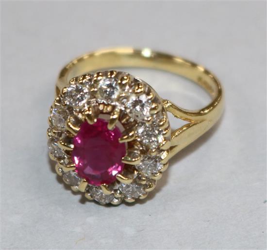 A modern 18ct gold, ruby and diamond oval cluster ring, size F.